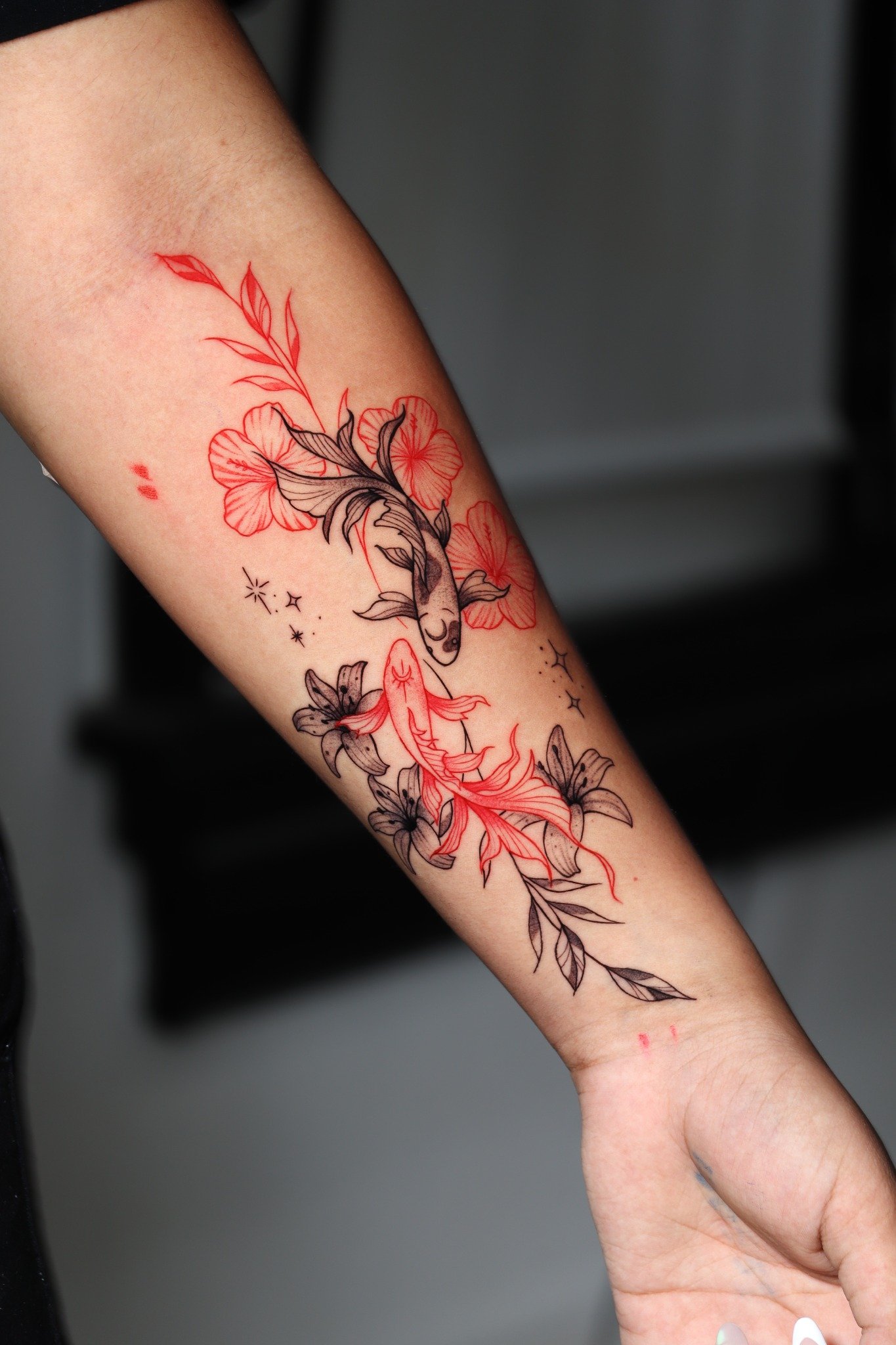 Tatuaje fine line de peces y flores